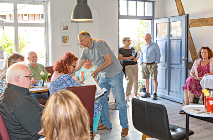 Gäste im Gastraum des Bürgercafés Ummerstadt mit Holzbalken und Bildern an den Wänden