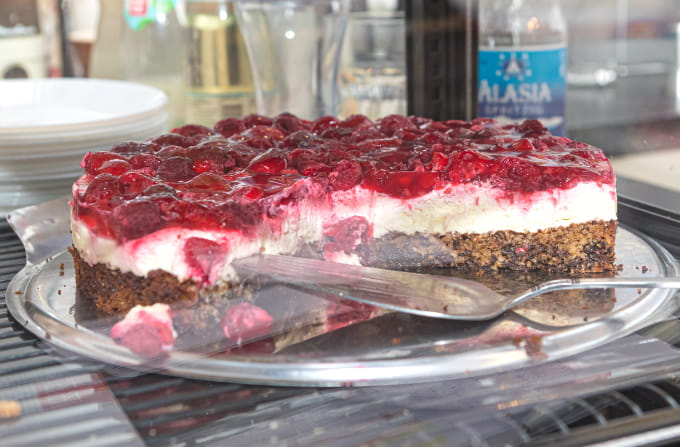 Stück Erdbeertorte und Cappuccino auf einem Holztisch im Bürgercafé Ummerstadt